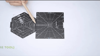 Demonstration of drawing three point perspective using black hexagon tool with measurement markings on white paper