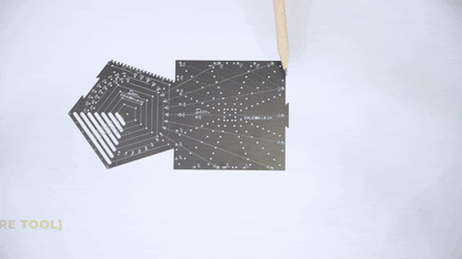 Demonstration on drawing three point perspective with black pentagon tool and black square tool on white paper