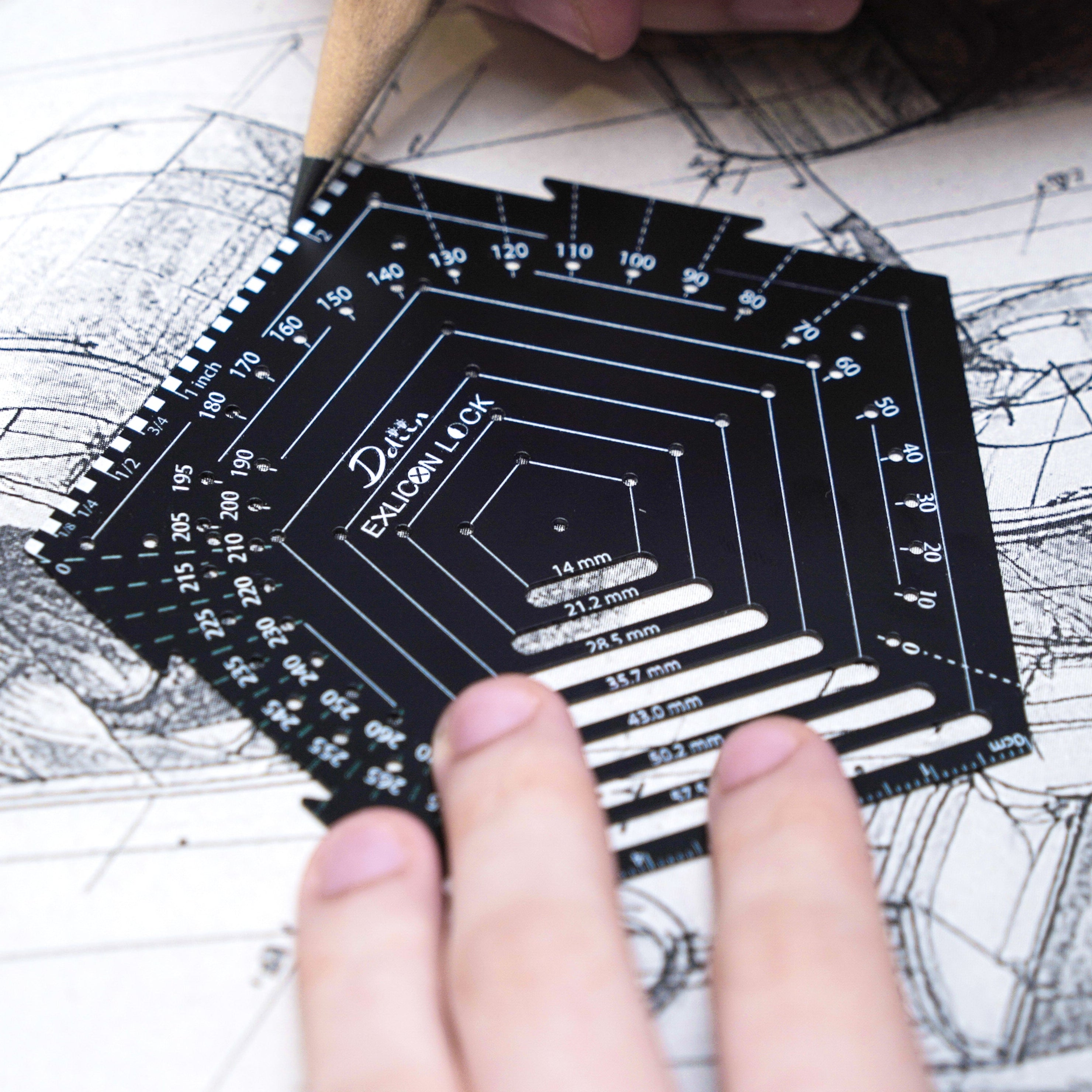 Person holding a black pentagon geometric tool over architectural drawings